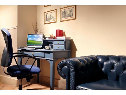 a desk with a computer and a chair in a room at Hotel Kennedy in Rome