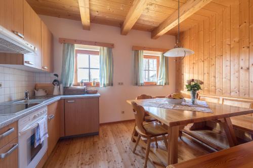 LiebenfelsにあるChalet zur Schmiedeの木製の天井、木製テーブル付きのキッチン