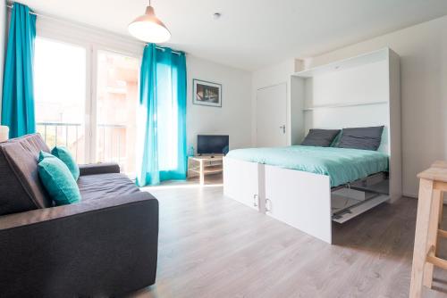 1 dormitorio con cama, sofá y espejo en Ombre Bleue en Toulouse