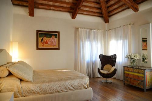 a bedroom with a bed and a chair at Villa Foscarini Cornaro in Gorgo al Monticano