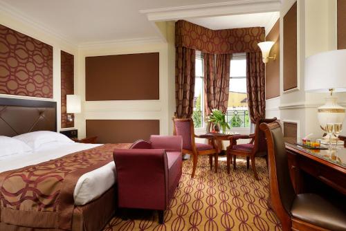a hotel room with a bed and a table and chairs at Grand Visconti Palace in Milan