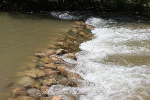 a stream of water with rocks in a river at La Farga de la Muga in Sant Llorenç de la Muga