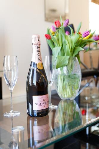 a bottle of wine sitting on a table with glasses at Wordsworth Apartment Irene court in Cockermouth