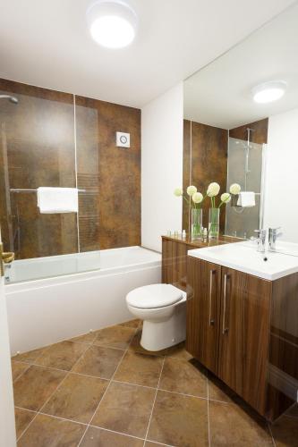 a bathroom with a toilet and a tub and a sink at Wordsworth Apartment Irene court in Cockermouth