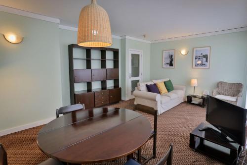 a living room with a table and a couch at Hotel Apartamento Solverde in Espinho