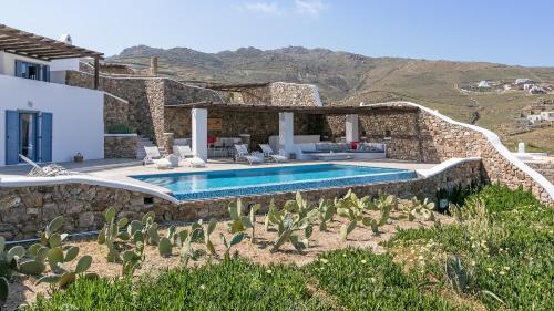 a villa with a swimming pool and a house at Mykonos Panormos Villas in Panormos Mykonos