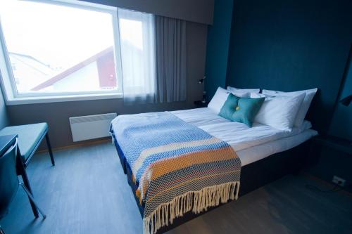 a bedroom with a large bed with a window at Hotel Marena in Andenes