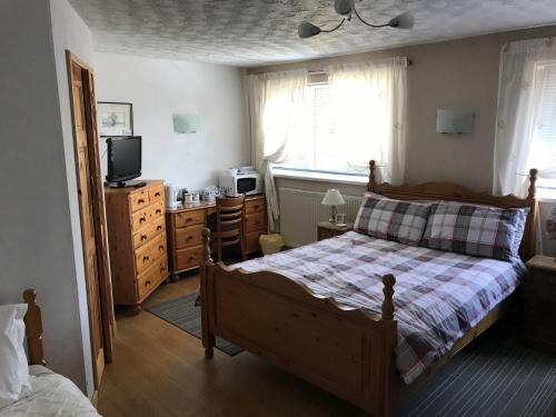 a bedroom with a bed and a dresser and a television at HP Bed and Breakfast in Congleton