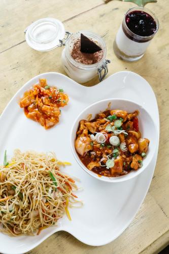 a plate of food with noodles and a bowl of food at Hotel Willow Banks Shimla in Shimla