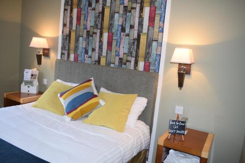 a bedroom with a bed with two tables and two lamps at Narrowboat at Weedon in Weedon Bec