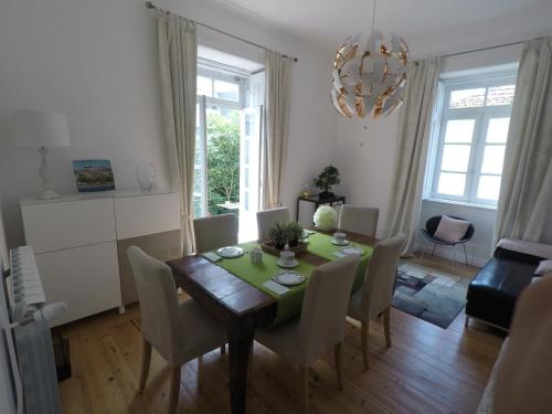 a dining room with a table with chairs and a chandelier at Casa Coimbra in Coimbra
