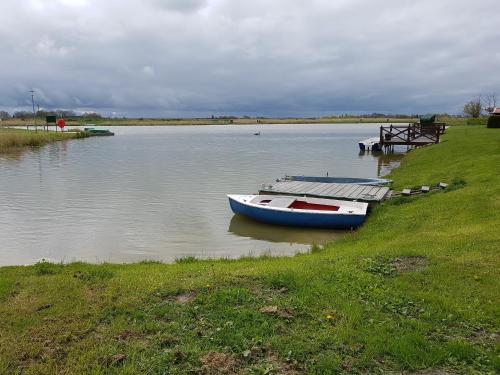 a boat sitting on the water next to a dock at Ferienhaus Poseidon in Neuharlingersiel
