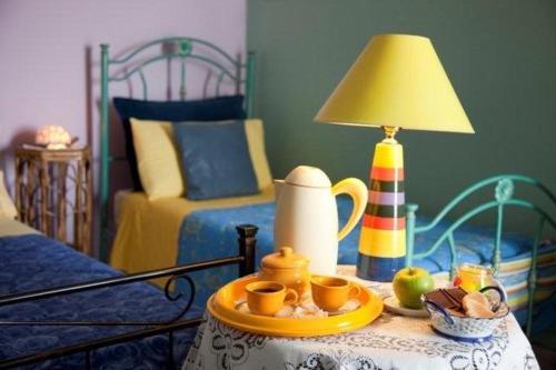 a room with a bed and a table with a lamp at B&B Kore in Enna