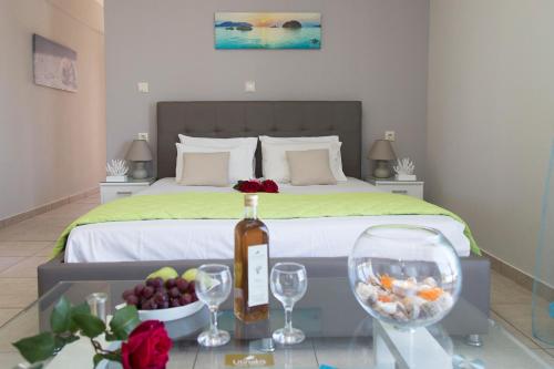 1 dormitorio con 1 cama con 1 botella de vino y copas de vino en Litinakis Studios, en Agia Marina de Nea Kydonia