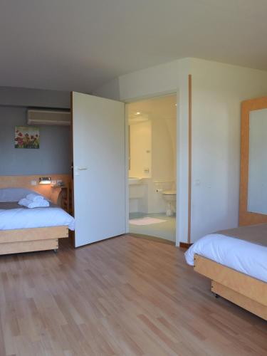 a large bedroom with two beds and a bathroom at Fasthôtel - Saint Emilion Est in Montcaret
