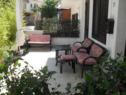 a porch with two chairs and a table and a bench at Apartments Colic in Herceg-Novi