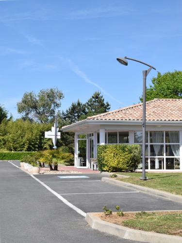a parking lot with a cross in front of a church at Fasthôtel - Saint Emilion Est in Montcaret