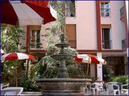 a fountain in front of a building with chairs and umbrellas at Hotel 5 Terre in Monterosso al Mare