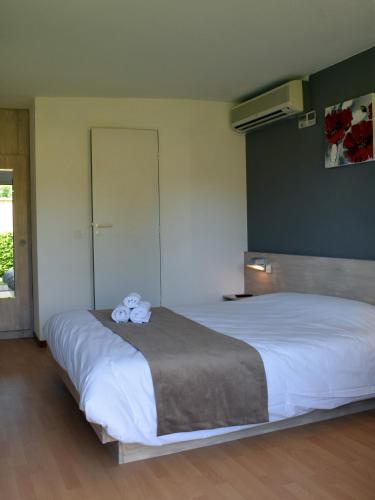 a bedroom with a large white bed with towels on it at Fasthôtel - Saint Emilion Est in Montcaret