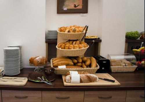 a table with baskets of bread and pastries on it at Hotel Admiral in Lipno nad Vltavou