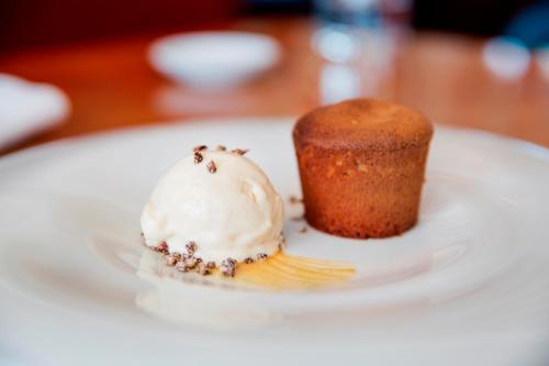 a white plate with a cupcake and a fork at Hotel Esplendido in Port de Soller