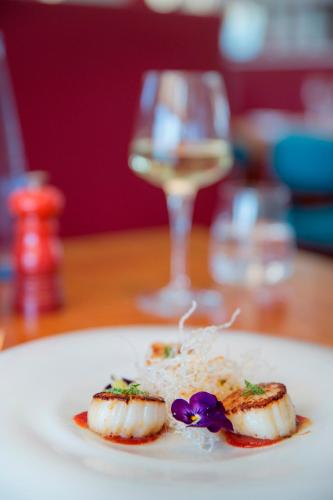 a white plate with food on a table with a glass at Hotel Esplendido in Port de Soller