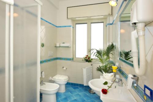 Hotel Pensione Reale في مايوري: حمام به مرحاض أبيض ومغسلة