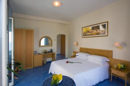 a hotel room with a white bed and a bathroom at Hotel Pensione Reale in Maiori