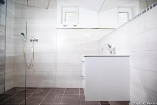 a white bathroom with a shower and a sink at Baltic Stone in Rewal