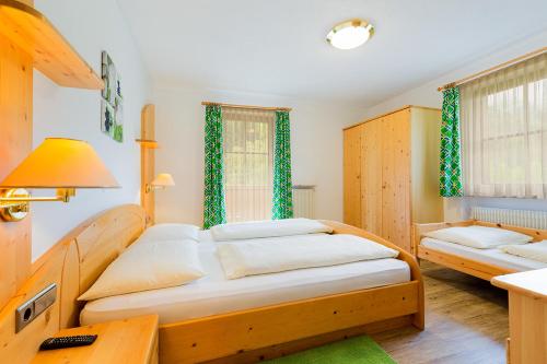 a bedroom with two beds with green curtains at Garni Bergland in Racines