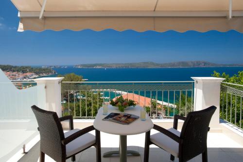Una mesa blanca y sillas en un balcón con vista. en Hotel Anezina, en Pylos