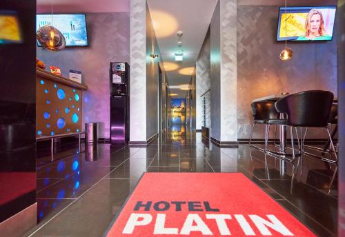 a hotel station with a red hotel placard on the floor at Hotel Platin in Regensburg