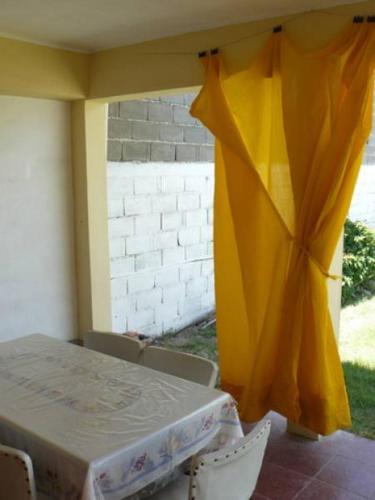 a table and chairs with a yellow curtain at Rocio de Luna in Mina Clavero