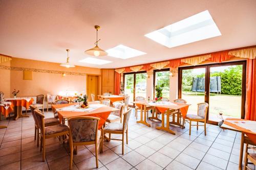 a restaurant with tables and chairs and windows at Pension Fischerhaus in Trassenheide