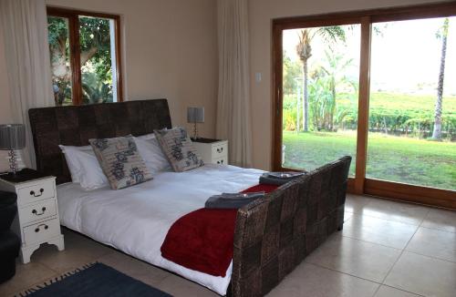 a bedroom with a large bed and a large window at Die Bult Plaas Guesthouse in Marchand