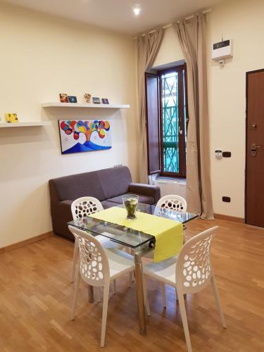 un soggiorno con tavolo, sedie e divano di La Casa Di Maryna a Napoli