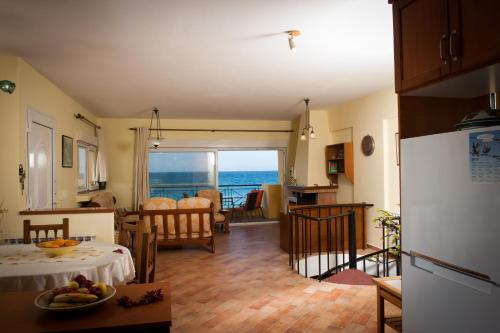 a kitchen and living room with a view of the ocean at Beach Villa Kalavarda in Kalavárda