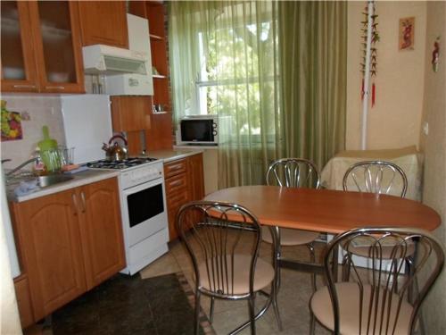 - une cuisine avec une table, des chaises, une table et une cuisinière dans l'établissement Apartment on Evreyskaya 42a, à Odessa