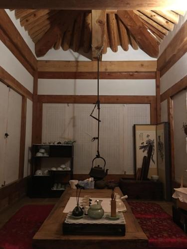 a room with a table with a chandelier hanging from the ceiling at Korean Traditional House - Chungnokdang in Boseong