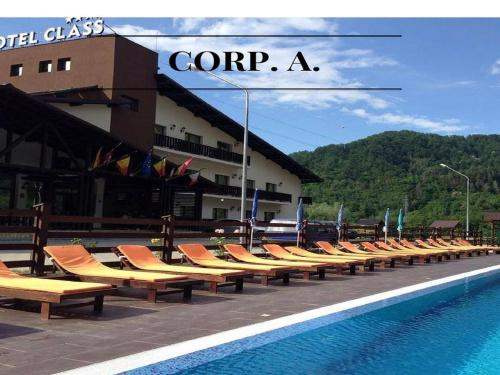 a row of lounge chairs next to a swimming pool at Hotel Class in Brezoi