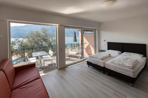 una camera con letto e balcone di Residence Parco Lago di Garda a Malcesine