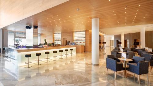 a lobby with chairs and a bar in a building at Hipotels Gran Playa de Palma in Playa de Palma