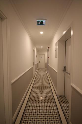 a hallway with a tile floor and a door at Hotel Naumpasa Konagi in Istanbul