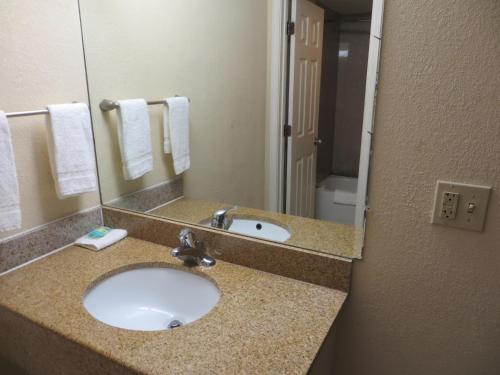 a bathroom with a sink and a mirror at Budget Inn in Cocoa