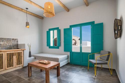 a room with a bed and a table and a chair at Nissia Beach Apartments & Suites in Kamari