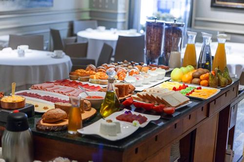 un buffet avec de nombreux types de nourriture sur une table dans l'établissement Hotel Europa, à Pampelune