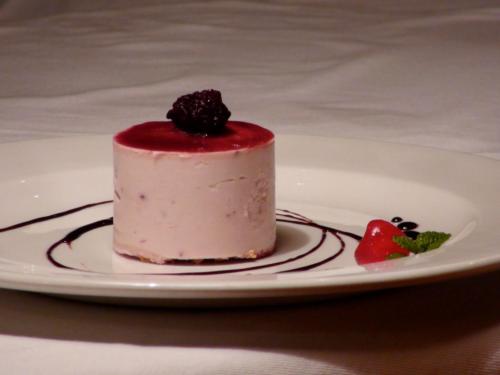 a piece of cake on a plate with a strawberry at Polokwane Place in Polokwane