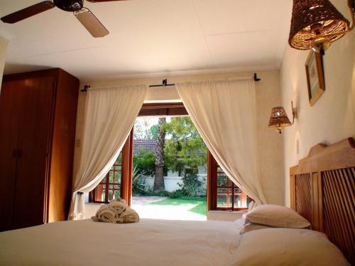a bedroom with a bed and a large window at Polokwane Place in Polokwane