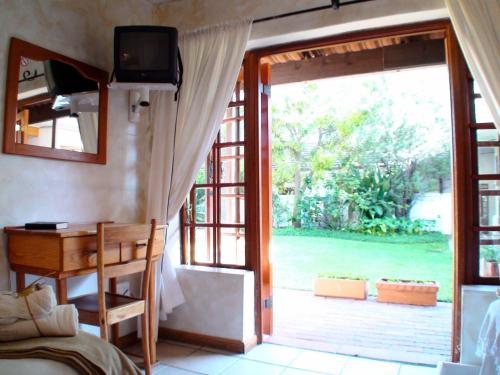 a bedroom with a door open to a garden at Polokwane Place in Polokwane