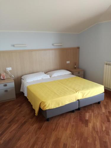 a bedroom with a large bed with a yellow blanket at Fonte Nuova Penne in Penne